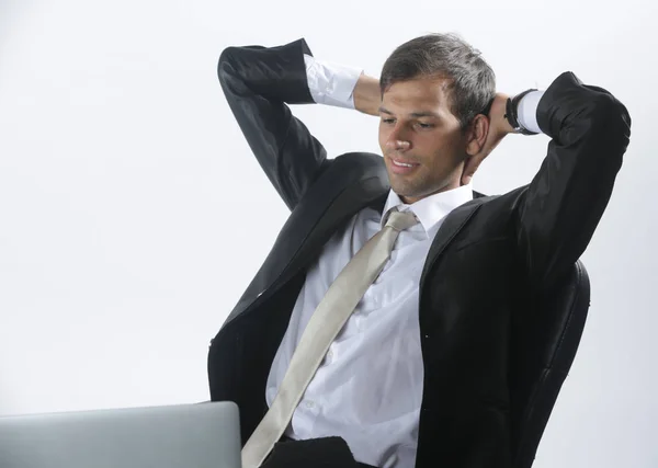 Dizüstü bilgisayar kullanarak ve onun ofisinde düşünme tişörtlü adam — Stok fotoğraf