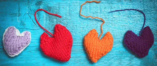 Coloridos corazones de punto en las tablas azules — Foto de Stock