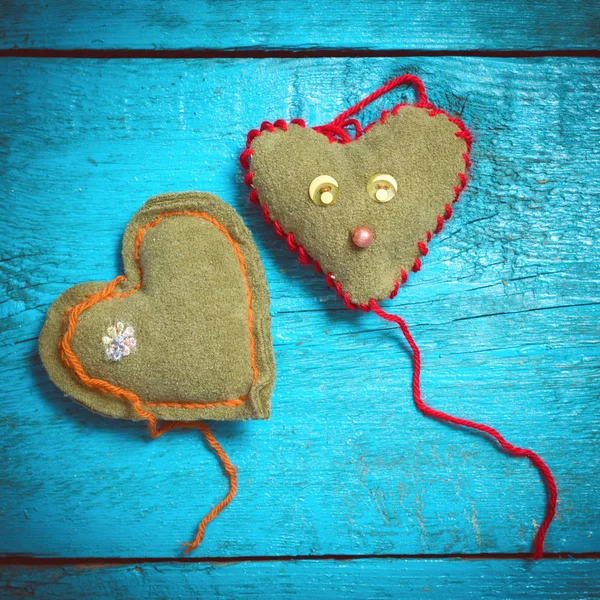 Colorful knitted hearts on the blue boards — Stock Photo, Image