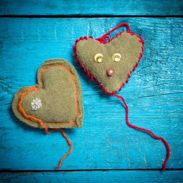 Colorful knitted hearts on the blue boards — Stock Photo, Image