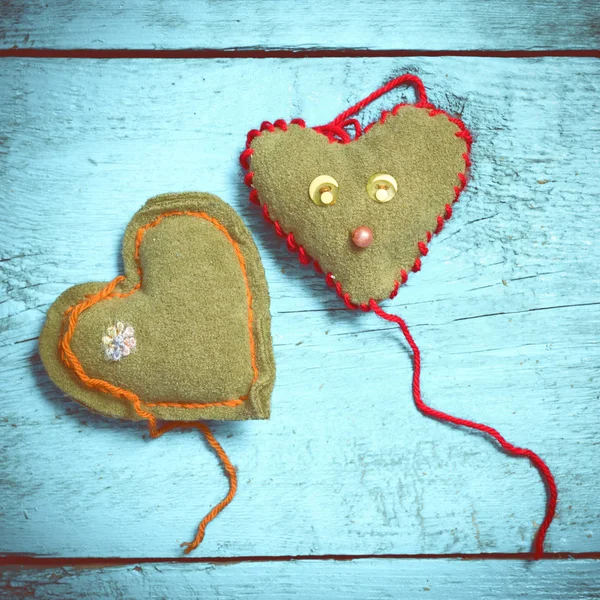 Colorful knitted hearts on the light blue boards — Stock Photo, Image