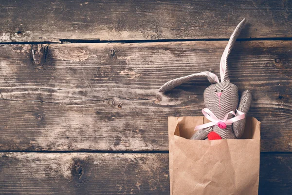 Osterhase in einer Papiertüte auf alten Brettern — Stockfoto