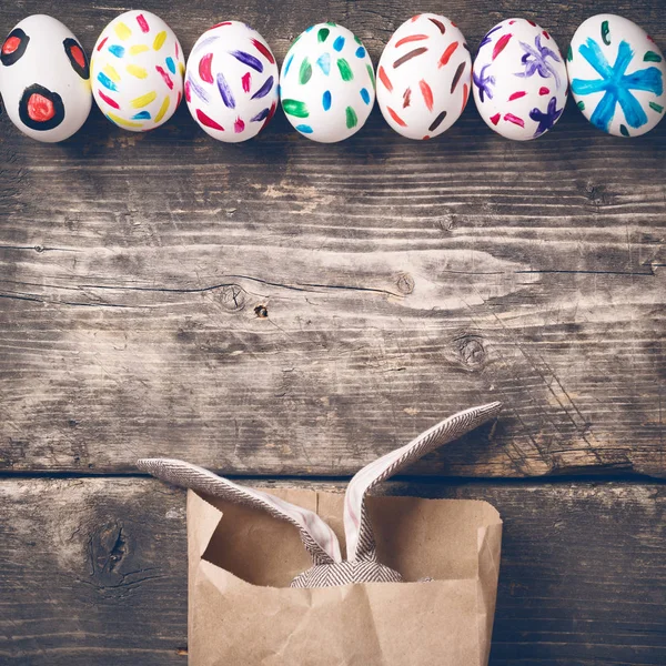 Conejito de Pascua en una bolsa de papel en tablas viejas — Foto de Stock