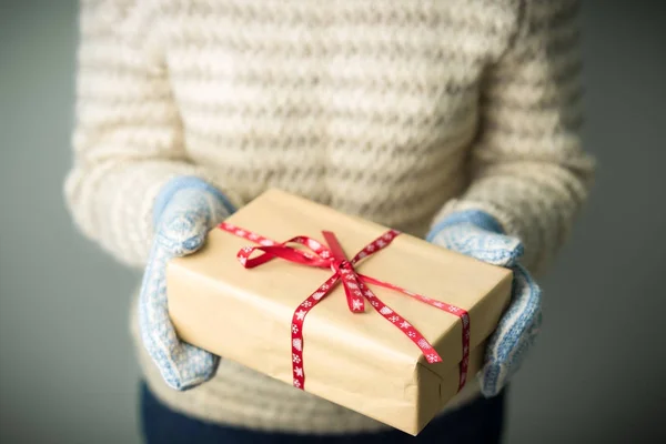 Uma menina segurando uma caixa com um presente de Natal — Fotografia de Stock