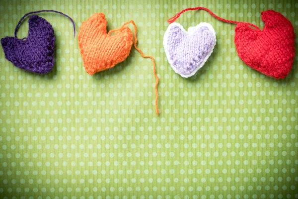 Valentines Day. Colorful knitted hearts on a vintage background in polka dots. Red heart. Green background. Valentine\'s day. Heart pendant. Valentine cards. Eighth of March. International Women\'s Day.