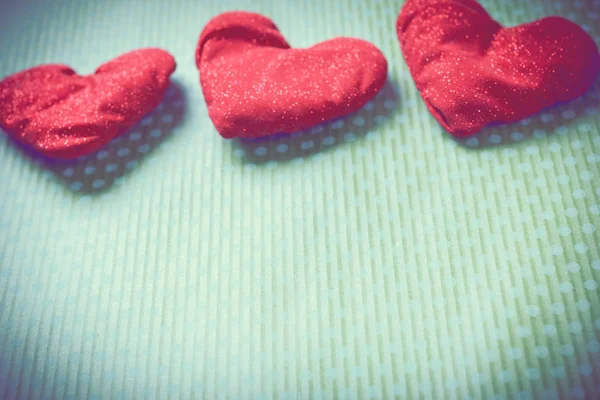 Colorful knitted hearts on a green background