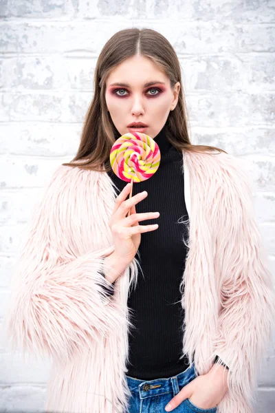 Una chica con una piruleta multicolor —  Fotos de Stock