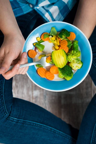 Ragazza con un piatto di verdure in mano — Foto Stock