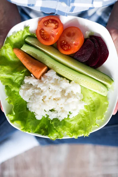 Ragazza con un piatto di verdure in mano — Foto Stock