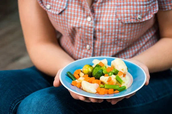 Ragazza con un piatto di verdure in mano — Foto Stock