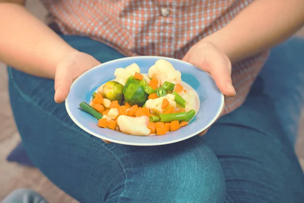 La ragazza tiene un piatto con verdure — Foto Stock