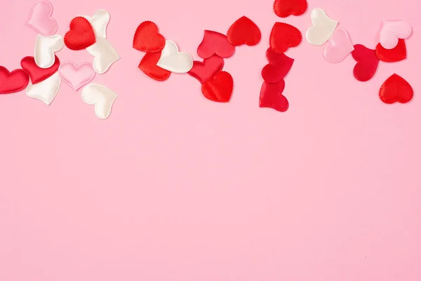 Güzel pembe bir arka planda sevgililer günü için kırmızı kalpler..