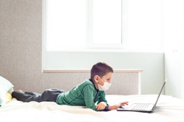 Evde kalıp koronavirüs salgınını önleyin. Bir çocuk karantina sırasında bilgisayarda öğreniyor. Mesafe öğrenme. Önleme salgını. COVID-19.