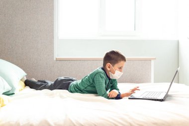 Evde kalıp koronavirüs salgınını önleyin. Bir çocuk karantina sırasında bilgisayarda öğreniyor. Mesafe öğrenme. Önleme salgını. COVID-19.