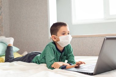 Evde kalıp koronavirüs salgınını önleyin. Bir çocuk karantina sırasında bilgisayarda öğreniyor. Mesafe öğrenme. Önleme salgını. COVID-19.