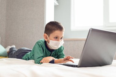 Evde kalıp koronavirüs salgınını önleyin. Bir çocuk karantina sırasında bilgisayarda öğreniyor. Mesafe öğrenme. Önleme salgını. COVID-19.