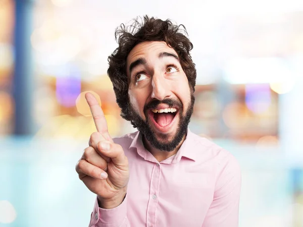 Surprised young man pointing up — Stock Photo, Image