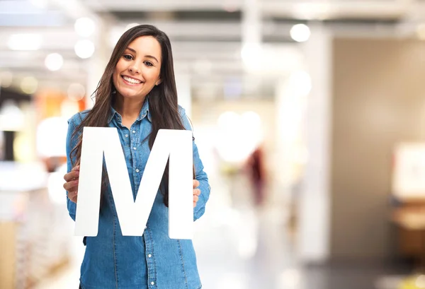 Happy young woman with letter m — Stock Fotó