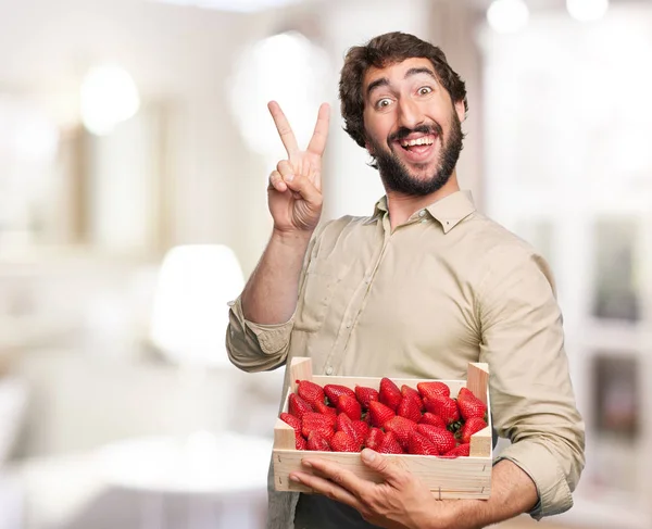 Šťastný mladý muž s jahodami — Stock fotografie