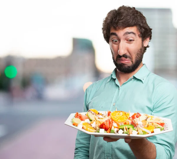 Young man with vomit sign and salad — Stock Photo, Image