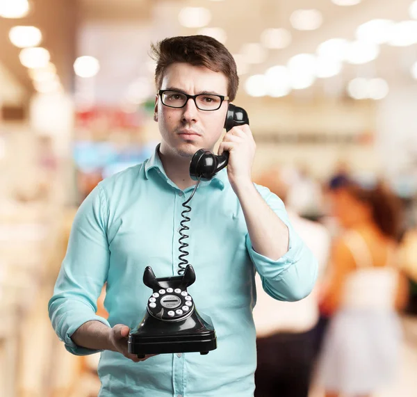 Confused young man with telephone — Stock Photo, Image