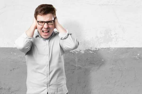 Glücklicher junger Mann, der die Ohren bedeckt — Stockfoto