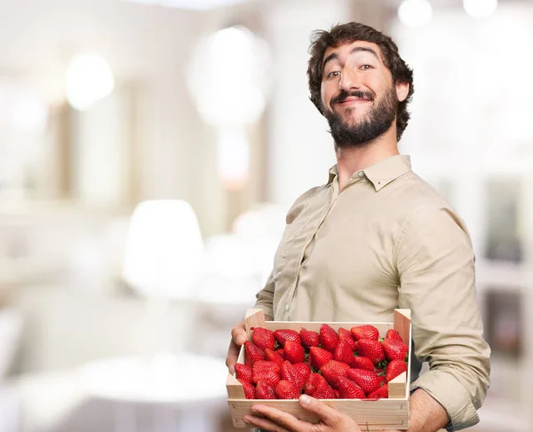 Happy young man with strawberries — Stock Photo, Image