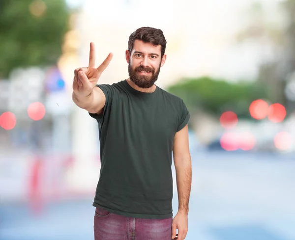 Heureux jeune homme avec signe de victoire — Photo