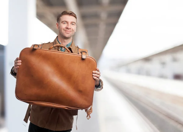 Verrast jonge man met koffer — Stockfoto