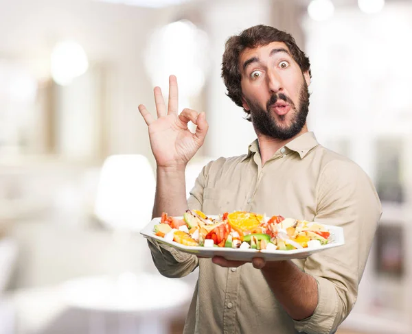 Felice giovane uomo con insalata — Foto Stock