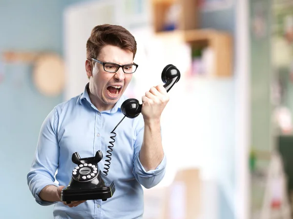 Angry young man met telefoon — Stockfoto