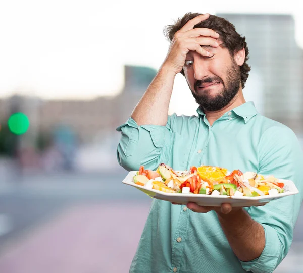 young man with vomit sign and salad