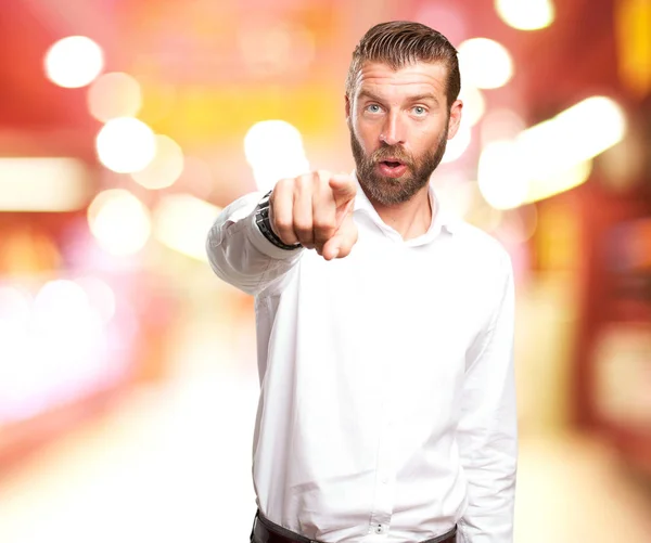 Überraschter junger Mann zeigt nach vorne — Stockfoto