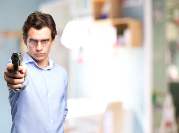 Angry young man with gun — Stock Photo, Image