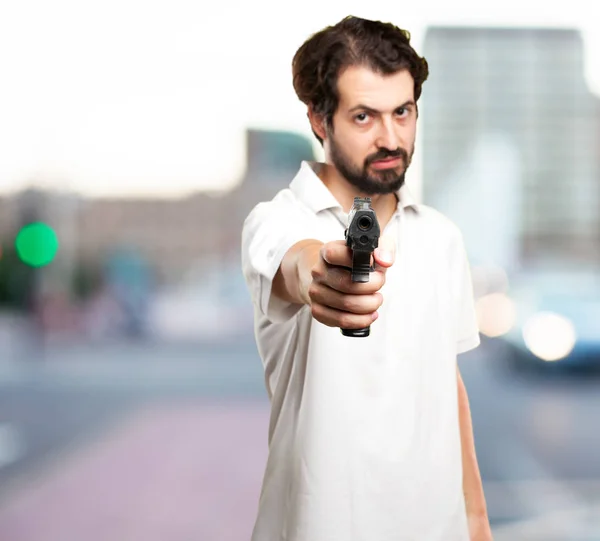 Angry young man with gun — Stock Photo, Image