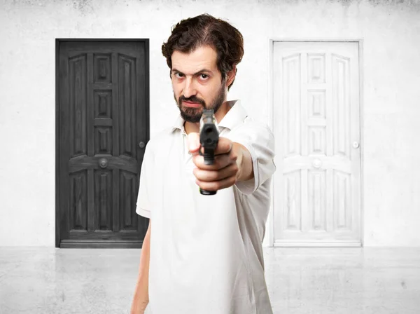 Angry young man with gun — Stock Photo, Image