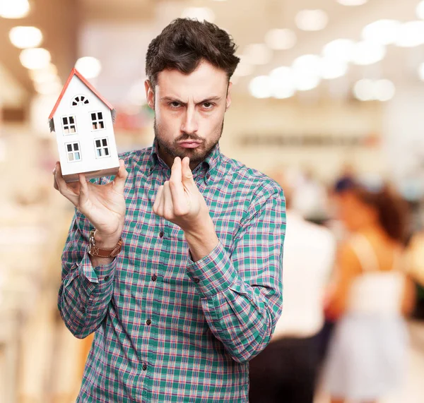 Wütender junger Mann mit Haus — Stockfoto