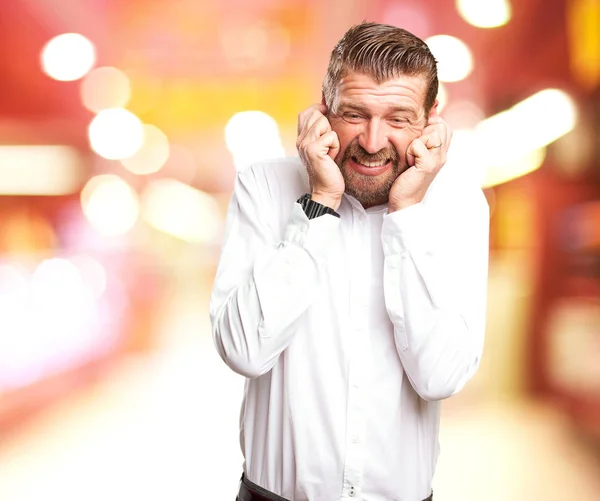 Überraschter junger Mann verdeckt Ohren — Stockfoto