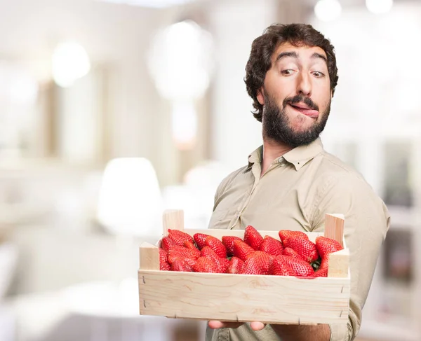 Gelukkig jonge man met aardbeien — Stockfoto