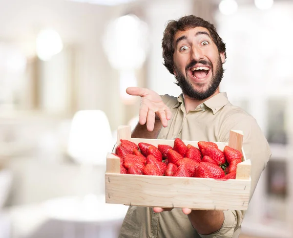 Glücklicher junger Mann mit Erdbeeren — Stockfoto