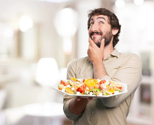 Счастливый молодой человек с салатом — стоковое фото