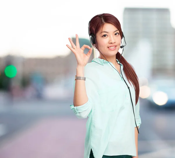 Mulher chinesa com bom sinal e fones de ouvido — Fotografia de Stock