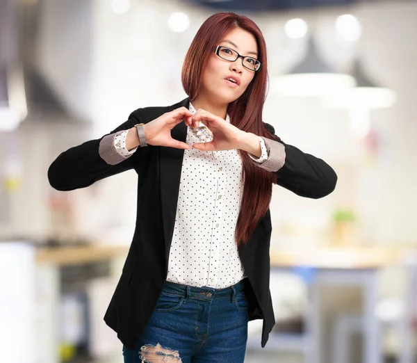 Happy chinese woman with heart symbol — Stock Photo, Image