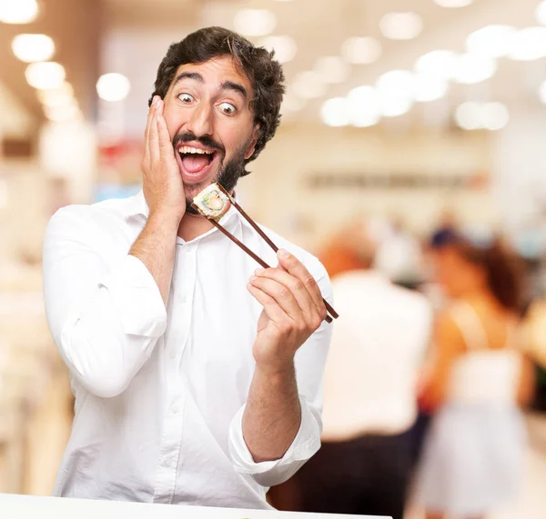 happy young man eating sushi