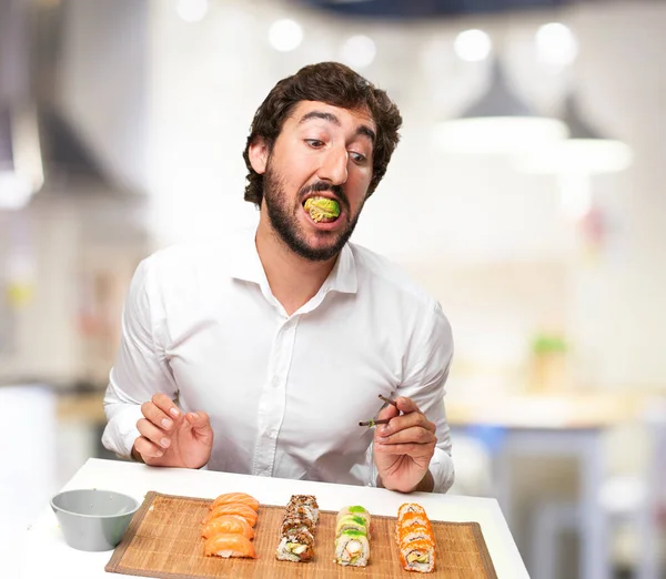 young man eating sushi