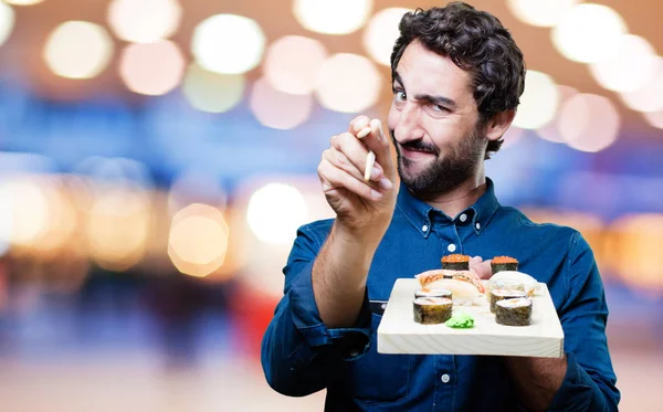 Человек ест суши и показывает знак — стоковое фото