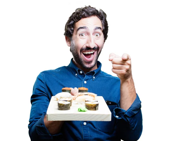 Человек ест суши и показывает знак — стоковое фото