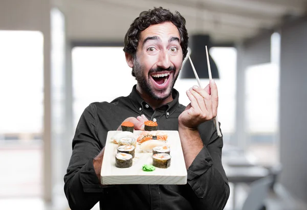 Молодой человек ест суши — стоковое фото