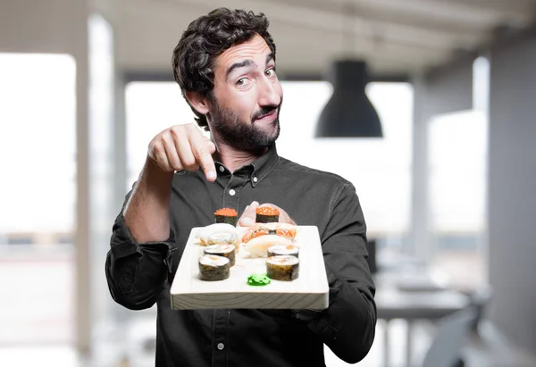 man eating sushi and showing sign