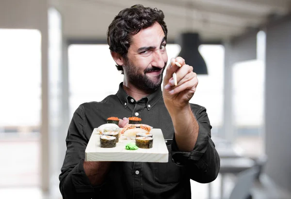 Hombre comiendo sushi y mostrando signo — Foto de Stock